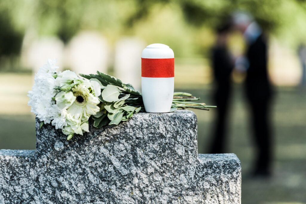 Urne et fleurs sur un monument funéraire en granit